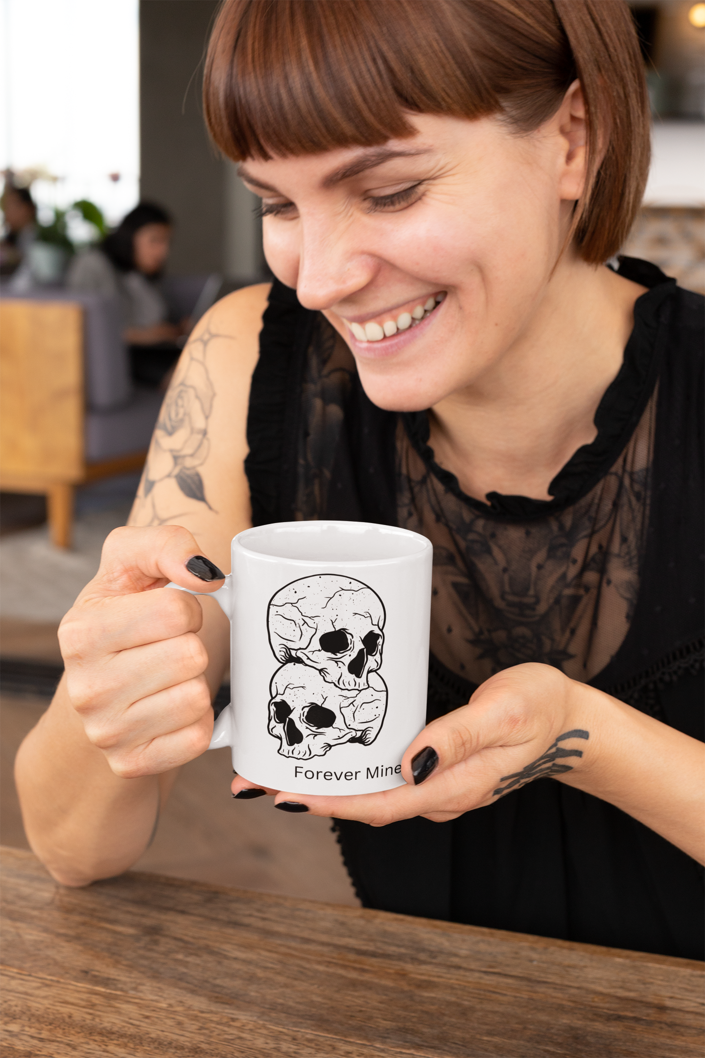 Woman holding a mug with skull design that says forever mine in a casual setting